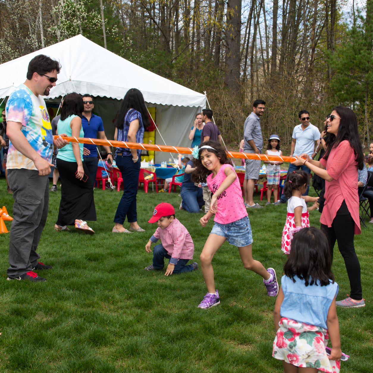 Children playing limbo during an interactive Bubble Party Pros event in Massachusetts