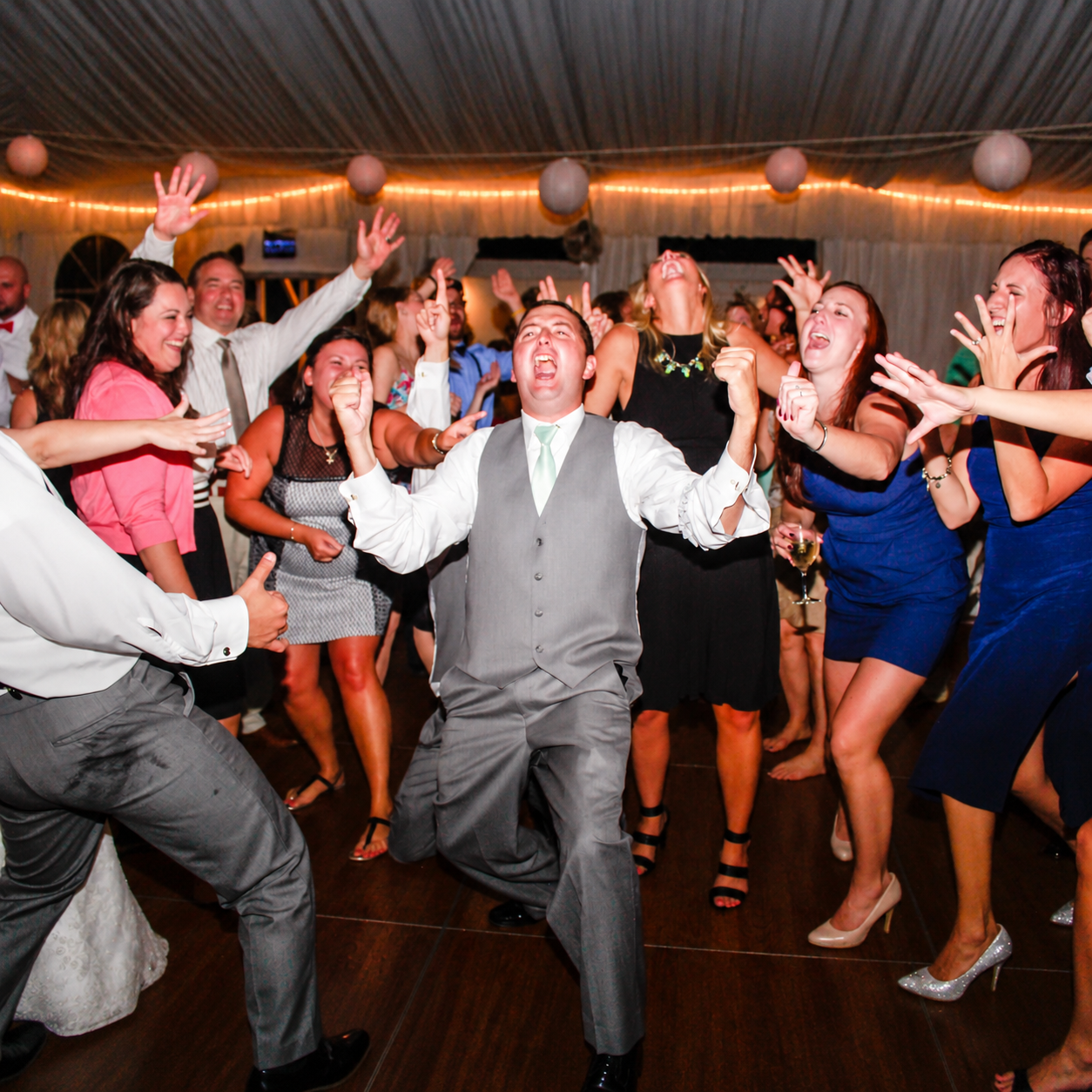 Guests singing and celebrating on a packed dance floor during a Magic Mike Entertainment event in Massachusetts