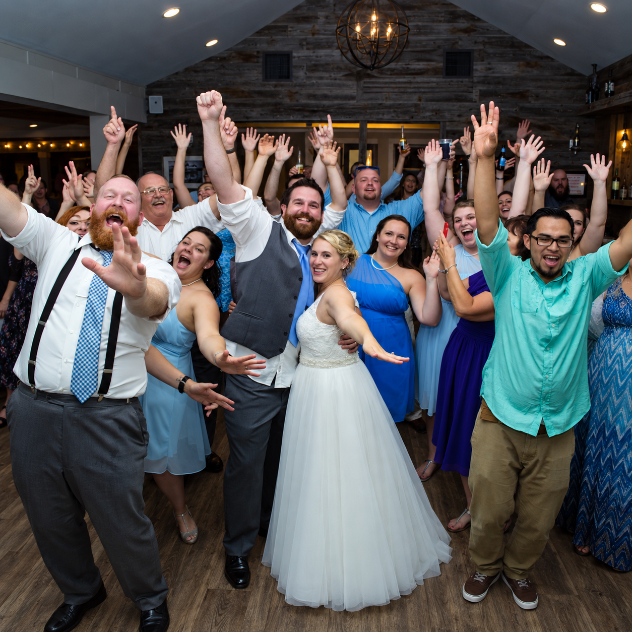 Bride, groom, and wedding guests celebrating together on the dance floor during a Magic Mike Entertainment event