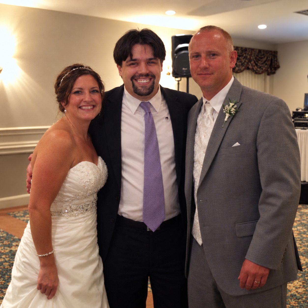 Mike from Magic Mike Entertainment with a bride and groom at a wedding reception